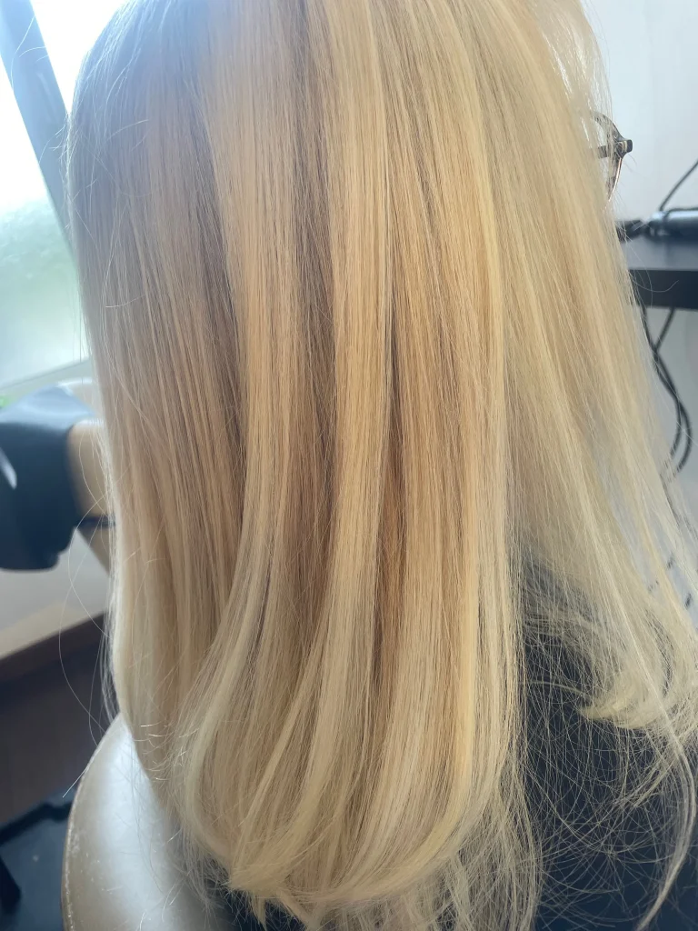Résultat d’un blond froid travaillé avec précision vu de profil droit – Emysphere Coiffure à Coudekerque