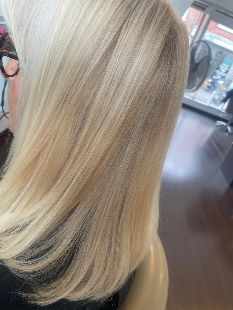Blond lumineux avec reflets froids vu de profil gauche, réalisé à Emysphere Coiffure à Coudekerque